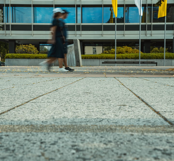Aufnahme des gepflasterten Coburger Bahnhofsplatzes mit vorbeigehenden Passanten – Referenzprojekt von Christian Knoch Tiefbau.