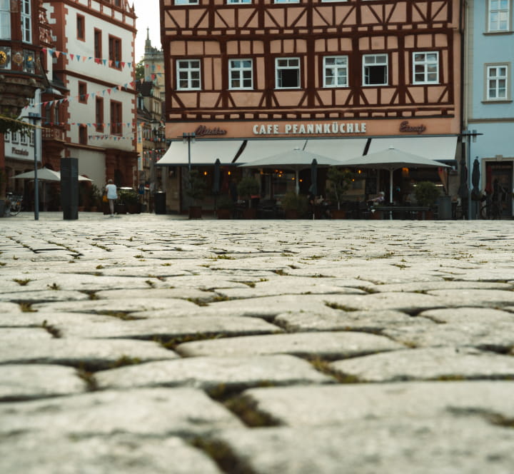Aufnahme des gepflasterten Coburger Marktplatzes mit historischen Fachwerkhäusern und Gastronomie